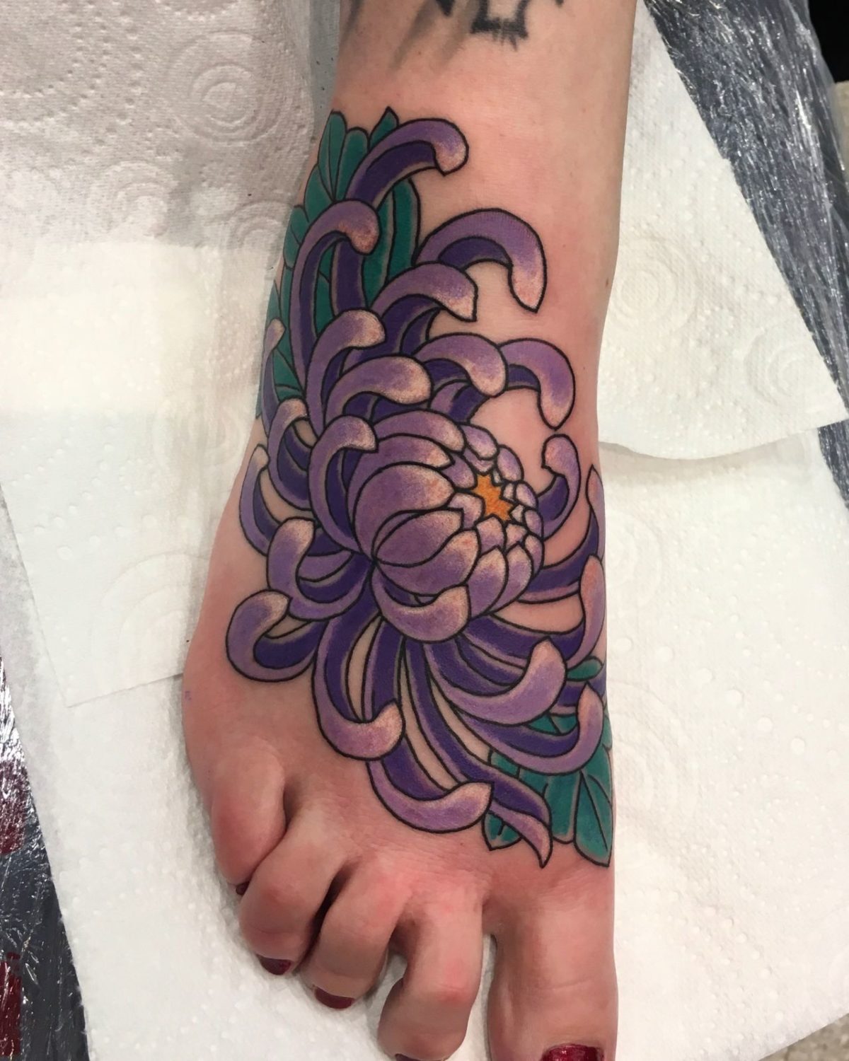 Xăm hình hoa cúc tím ở bàn chân